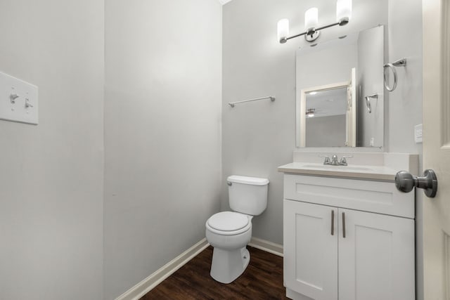 bathroom featuring hardwood / wood-style floors, vanity, toilet, and ceiling fan