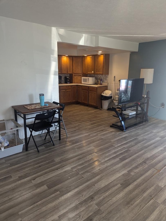 kitchen with backsplash and dark wood-type flooring