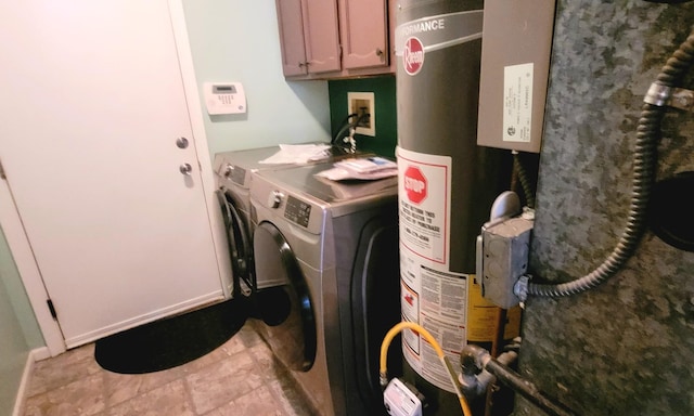 laundry area featuring washing machine and clothes dryer, cabinets, and water heater