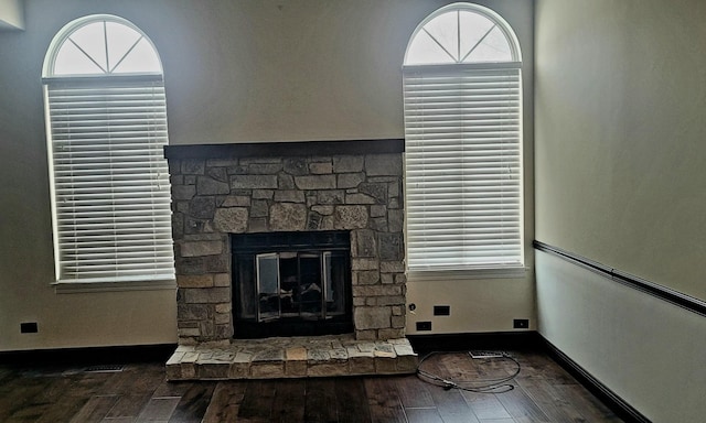 room details featuring wood-type flooring and a stone fireplace