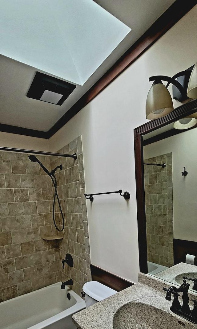 full bathroom featuring tiled shower / bath combo, toilet, and vanity