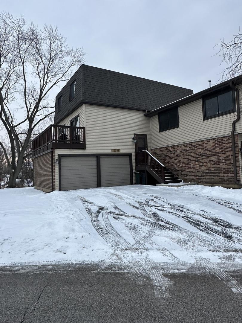 snow covered property with a garage