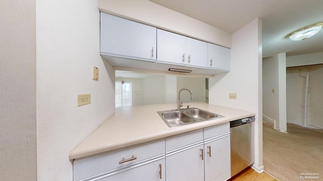 kitchen featuring white cabinetry, dishwasher, sink, and light carpet