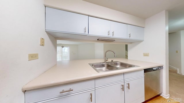 kitchen featuring white cabinets, stainless steel dishwasher, and sink