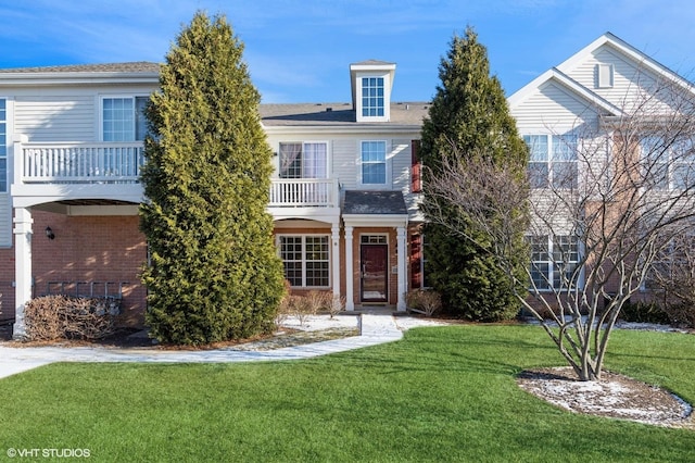 view of front of house featuring a balcony and a front yard