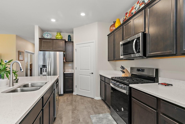 kitchen with light hardwood / wood-style floors, sink, dark brown cabinetry, appliances with stainless steel finishes, and light stone counters