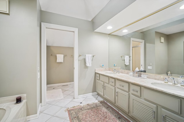 bathroom with a tub to relax in, tile patterned floors, and vanity