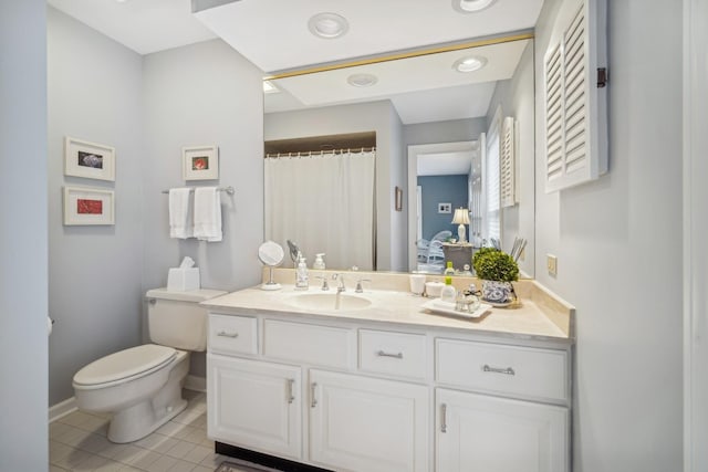 bathroom featuring toilet, vanity, and tile patterned flooring