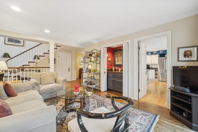 living room featuring crown molding and light hardwood / wood-style floors