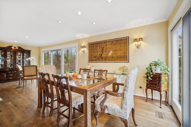 dining space with ornamental molding and wood-type flooring