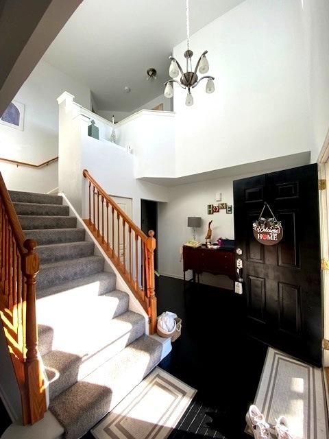 entrance foyer with a towering ceiling and a chandelier