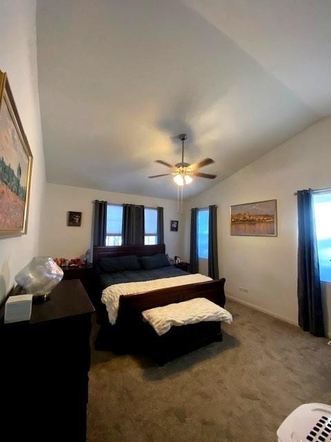 bedroom featuring ceiling fan, carpet floors, multiple windows, and vaulted ceiling