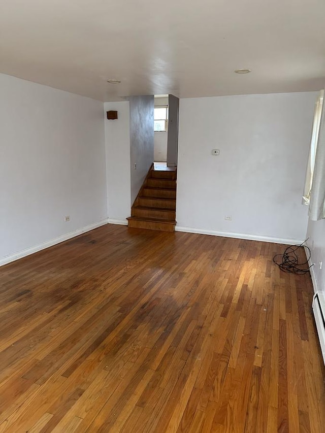 spare room with a baseboard heating unit and wood-type flooring