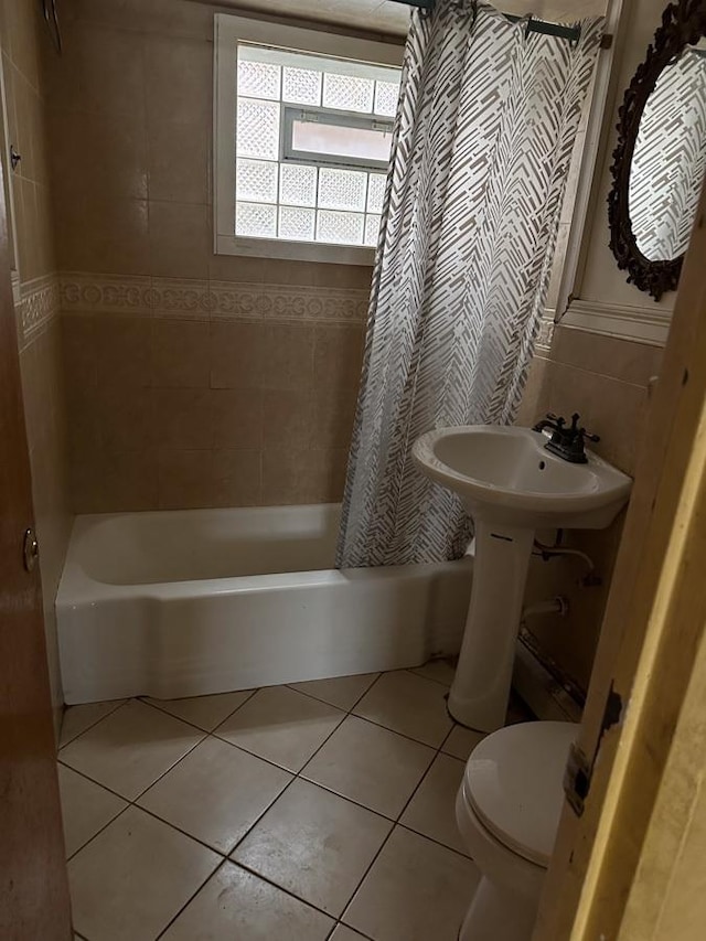 bathroom with shower / tub combo with curtain, tile patterned floors, and toilet