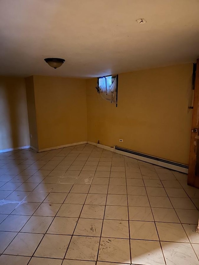 basement featuring light tile patterned flooring and a baseboard heating unit