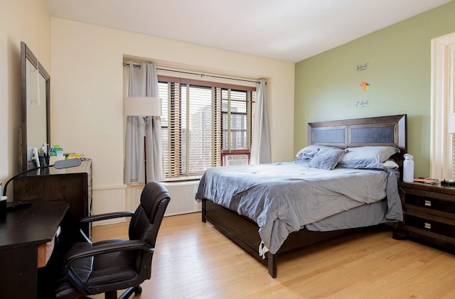 bedroom featuring radiator heating unit and light hardwood / wood-style flooring