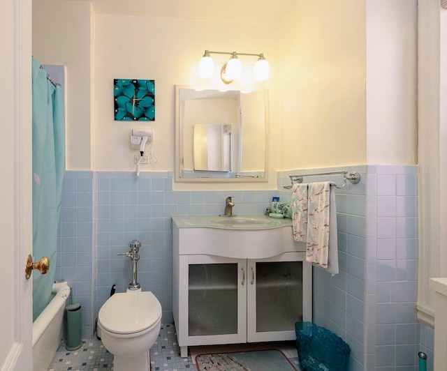 bathroom with toilet, vanity, tile patterned floors, and tile walls