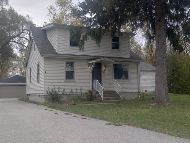 view of front of house with an outbuilding, a garage, and a front lawn