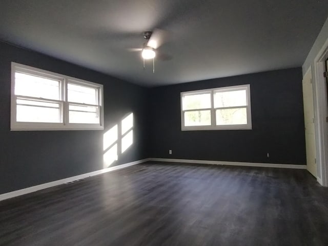 spare room featuring ceiling fan and dark wood-type flooring