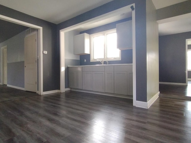 kitchen with dark hardwood / wood-style flooring, white cabinets, and sink