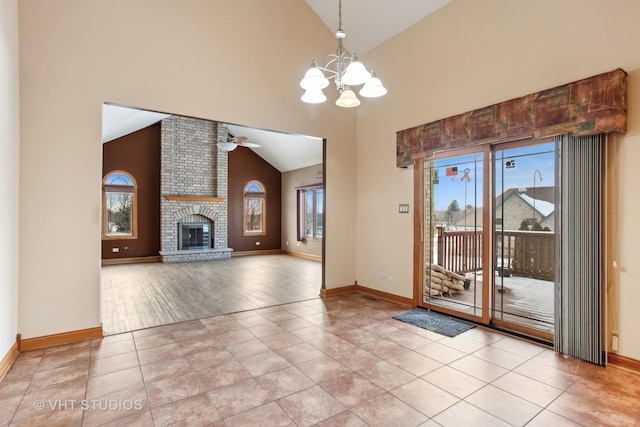 interior space featuring ceiling fan with notable chandelier, a fireplace, and light tile patterned flooring