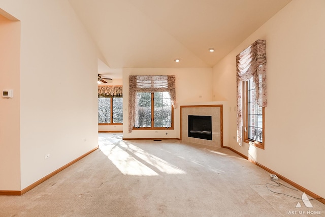 unfurnished living room featuring ceiling fan, a fireplace, high vaulted ceiling, and light colored carpet