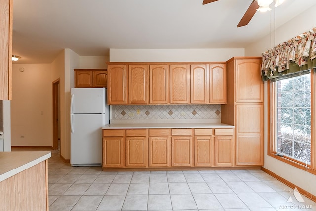 kitchen featuring ceiling fan, white refrigerator, light tile patterned floors, and tasteful backsplash