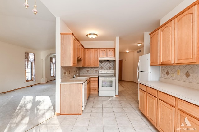 kitchen with decorative backsplash, light tile patterned flooring, white appliances, and light brown cabinetry