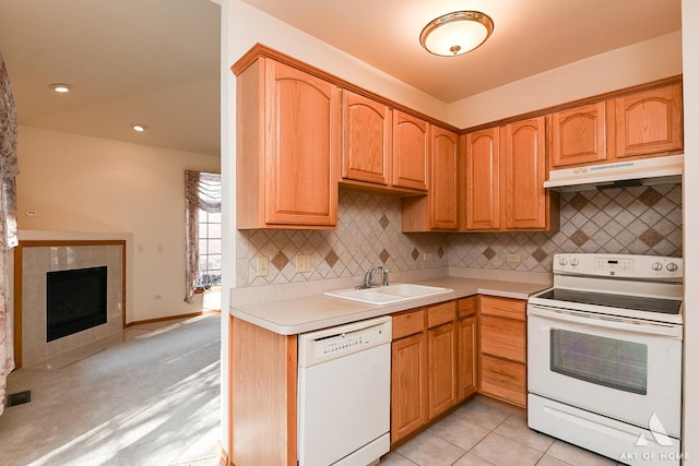 kitchen featuring decorative backsplash, white appliances, sink, light tile patterned floors, and a fireplace