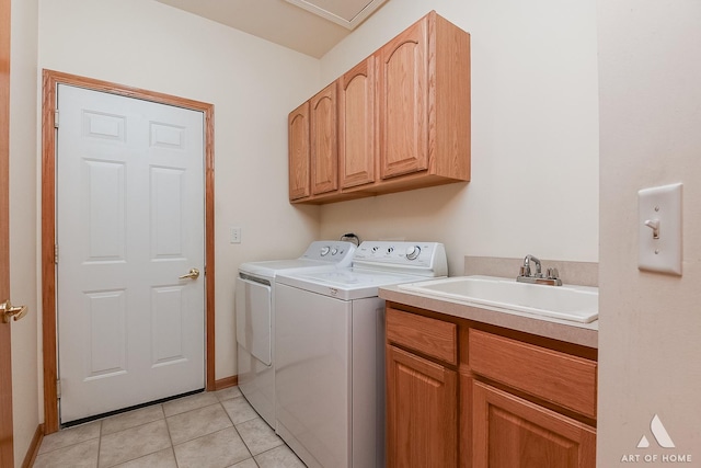 washroom with cabinets, light tile patterned floors, washing machine and clothes dryer, and sink