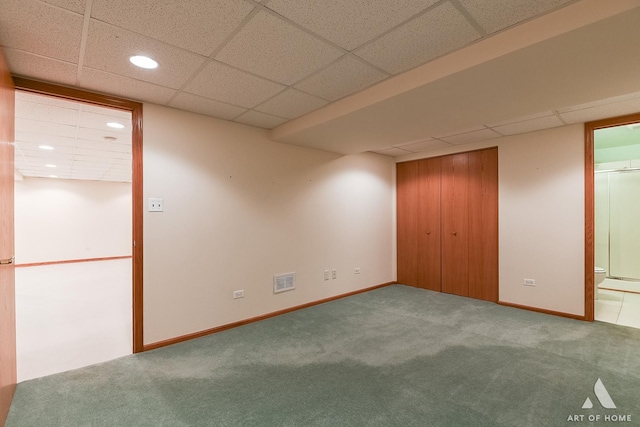 unfurnished bedroom with carpet flooring, a paneled ceiling, ensuite bath, and a closet