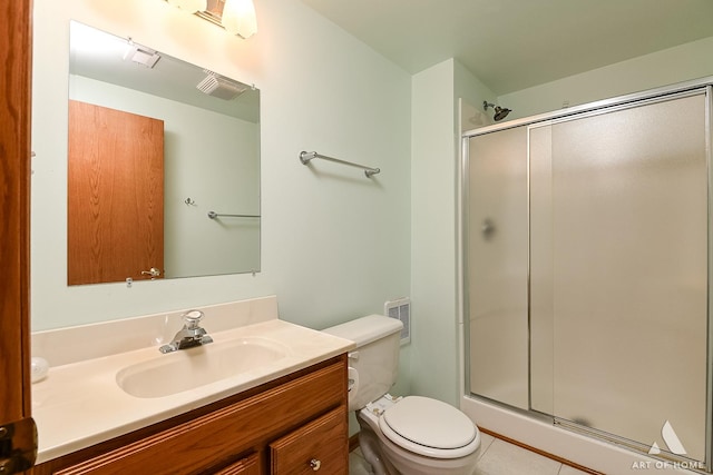 bathroom featuring tile patterned flooring, vanity, toilet, and a shower with shower door