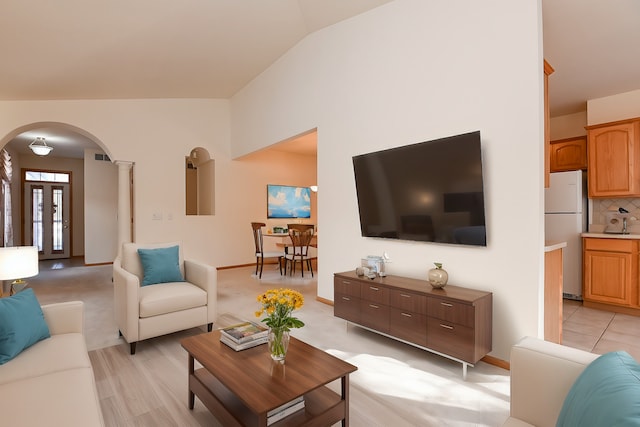 living room with ornate columns and vaulted ceiling