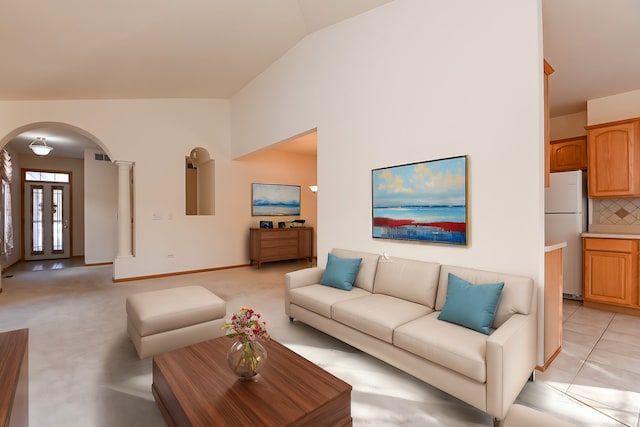 living room featuring light tile patterned floors, decorative columns, and vaulted ceiling