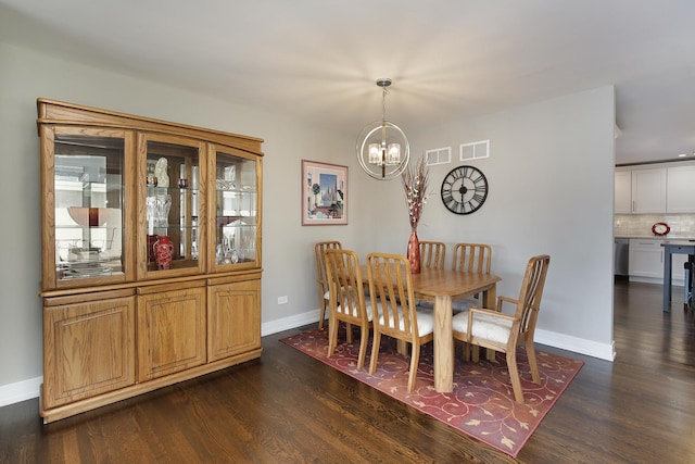 dining space featuring a notable chandelier and dark wood-type flooring