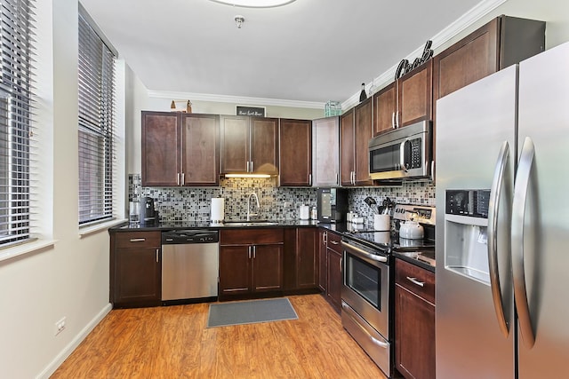 kitchen with sink, appliances with stainless steel finishes, light hardwood / wood-style flooring, and crown molding