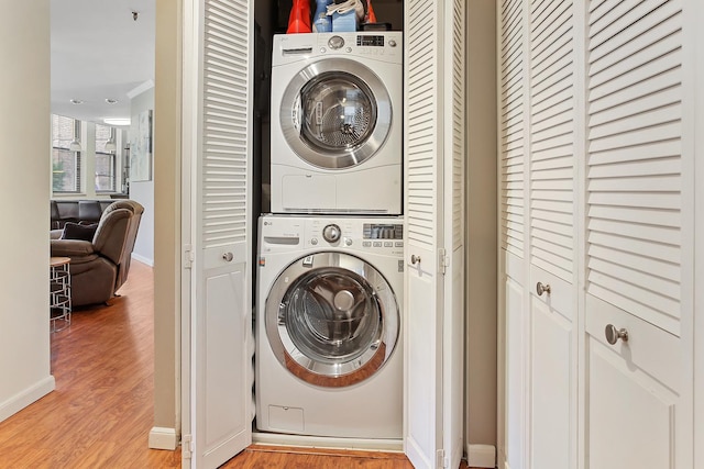 laundry area featuring light hardwood / wood-style floors and stacked washer and clothes dryer