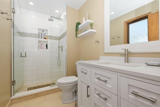 bathroom featuring walk in shower, vanity, toilet, and tile patterned flooring