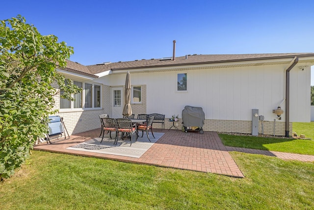 rear view of property featuring a patio area and a lawn