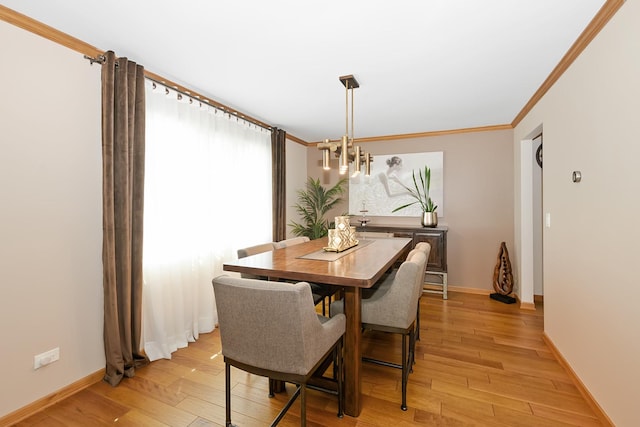 dining space with crown molding and light hardwood / wood-style flooring