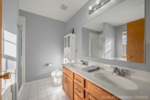 bathroom featuring tile patterned floors, toilet, a shower with door, and vanity