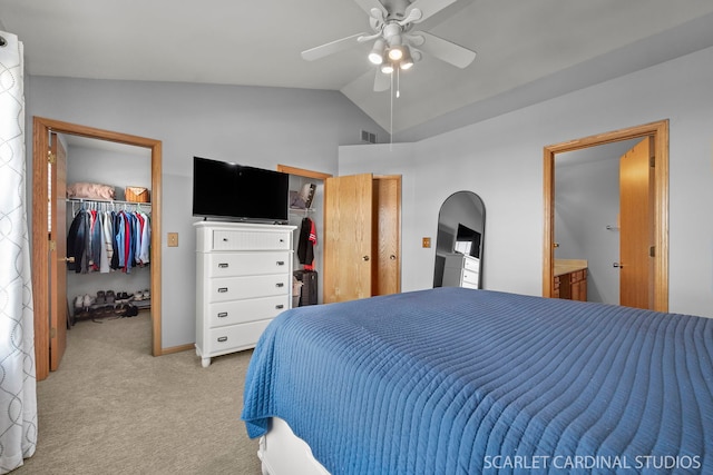 bedroom with connected bathroom, vaulted ceiling, light colored carpet, and ceiling fan