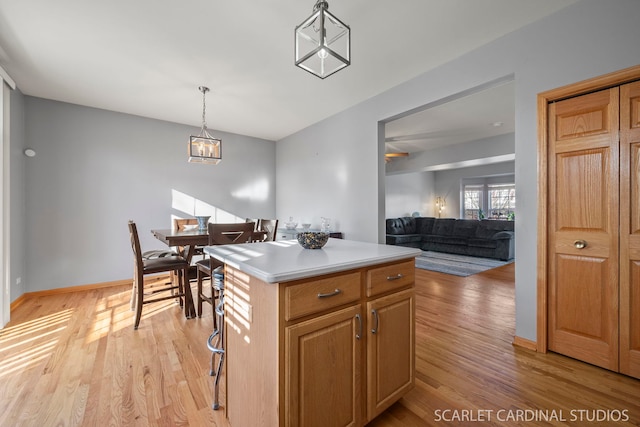 kitchen with pendant lighting, light hardwood / wood-style flooring, and a center island