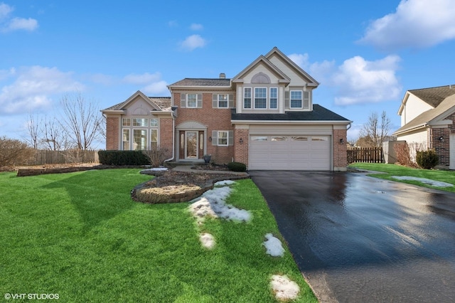 traditional-style home with driveway, brick siding, and fence