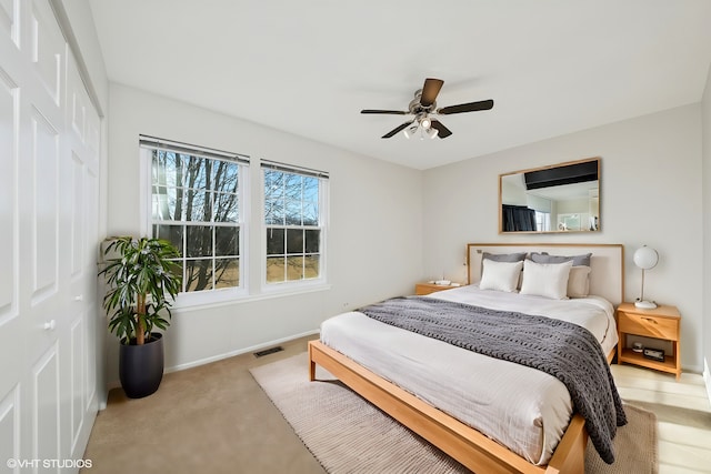 bedroom featuring a ceiling fan, baseboards, visible vents, and a closet