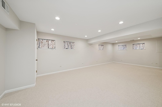 finished below grade area featuring visible vents, light colored carpet, and recessed lighting