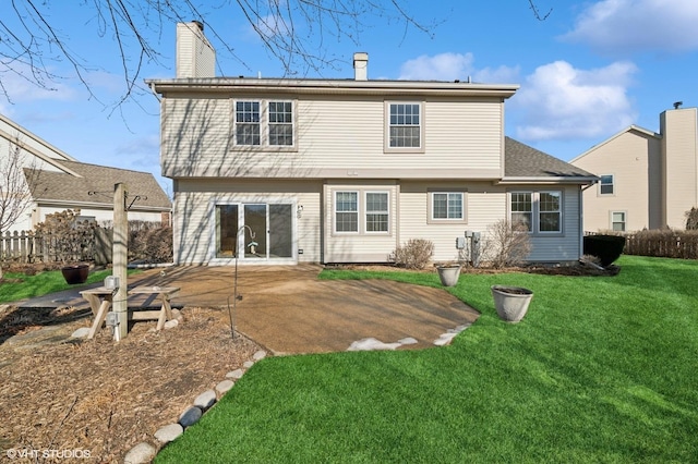 back of house with a patio, a lawn, a chimney, and fence