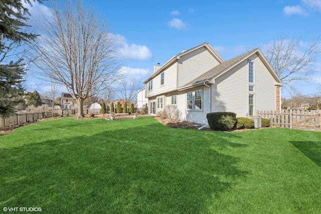 exterior space featuring a fenced backyard, a yard, and a chimney