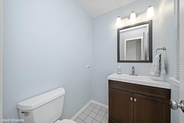 bathroom featuring baseboards, vanity, toilet, and tile patterned floors