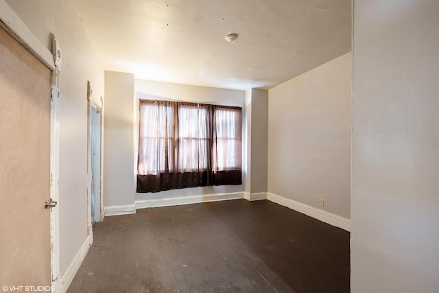 spare room featuring dark wood-type flooring